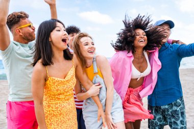 Multiethnic group of young happy friends bonding outside, having fun on summertime vacation - Multicultural cheerful people with summer clothes enjoying summer holidays, concepts about youth, friendship and positive emotion