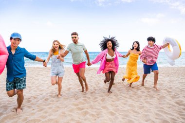 Multiethnic group of young happy friends bonding outside, having fun on summertime vacation - Multicultural cheerful people with summer clothes enjoying summer holidays, concepts about youth, friendship and positive emotion