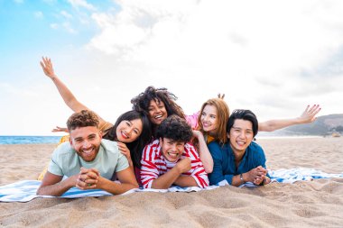 Multiethnic group of young happy friends bonding outside, having fun on summertime vacation - Multicultural cheerful people with summer clothes enjoying summer holidays, concepts about youth, friendship and positive emotion
