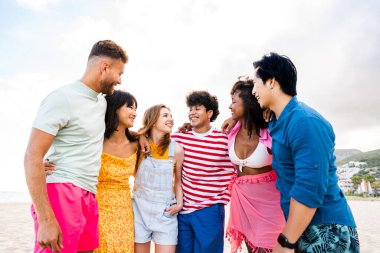 Multiethnic group of young happy friends bonding outside, having fun on summertime vacation - Multicultural cheerful people with summer clothes enjoying summer holidays, concepts about youth, friendship and positive emotion