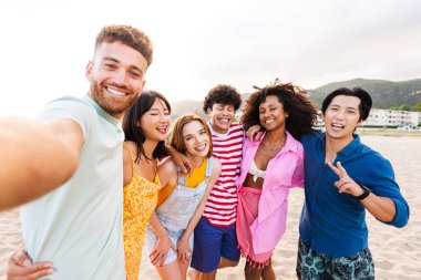 Multiethnic group of young happy friends bonding outside, having fun on summertime vacation - Multicultural cheerful people with summer clothes enjoying summer holidays, concepts about youth, friendship and positive emotion