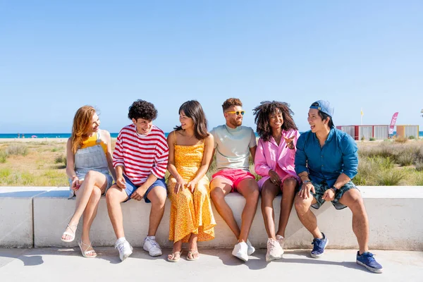 Multiethnic group of young happy friends bonding outside, having fun on summertime vacation - Multicultural cheerful people with summer clothes enjoying summer holidays, concepts about youth, friendship and positive emotion