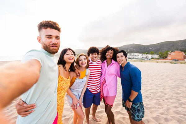 Multiethnic group of young happy friends bonding outside, having fun on summertime vacation - Multicultural cheerful people with summer clothes enjoying summer holidays, concepts about youth, friendship and positive emotion