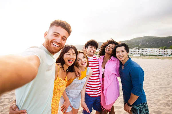 Multiethnic group of young happy friends bonding outside, having fun on summertime vacation - Multicultural cheerful people with summer clothes enjoying summer holidays, concepts about youth, friendship and positive emotion