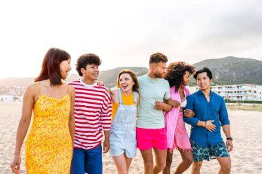 Multiethnic group of young happy friends bonding outside, having fun on summertime vacation - Multicultural cheerful people with summer clothes enjoying summer holidays, concepts about youth, friendship and positive emotion