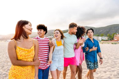 Multiethnic group of young happy friends bonding outside, having fun on summertime vacation - Multicultural cheerful people with summer clothes enjoying summer holidays, concepts about youth, friendship and positive emotion