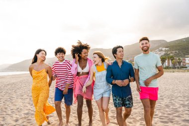 Multiethnic group of young happy friends bonding outside, having fun on summertime vacation - Multicultural cheerful people with summer clothes enjoying summer holidays, concepts about youth, friendship and positive emotion