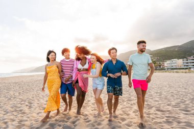 Multiethnic group of young happy friends bonding outside, having fun on summertime vacation - Multicultural cheerful people with summer clothes enjoying summer holidays, concepts about youth, friendship and positive emotion