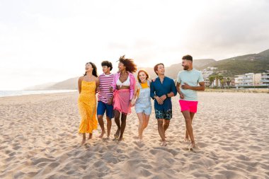 Multiethnic group of young happy friends bonding outside, having fun on summertime vacation - Multicultural cheerful people with summer clothes enjoying summer holidays, concepts about youth, friendship and positive emotion