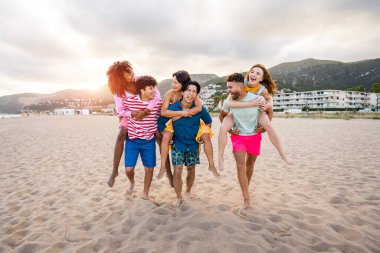 Multiethnic group of young happy friends bonding outside, having fun on summertime vacation - Multicultural cheerful people with summer clothes enjoying summer holidays, concepts about youth, friendship and positive emotion
