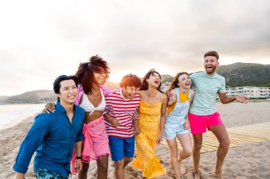 Multiethnic group of young happy friends bonding outside, having fun on summertime vacation - Multicultural cheerful people with summer clothes enjoying summer holidays, concepts about youth, friendship and positive emotion
