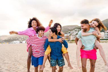 Multiethnic group of young happy friends bonding outside, having fun on summertime vacation - Multicultural cheerful people with summer clothes enjoying summer holidays, concepts about youth, friendship and positive emotion