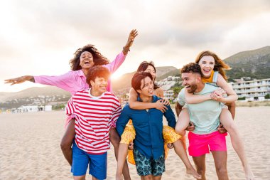 Multiethnic group of young happy friends bonding outside, having fun on summertime vacation - Multicultural cheerful people with summer clothes enjoying summer holidays, concepts about youth, friendship and positive emotion