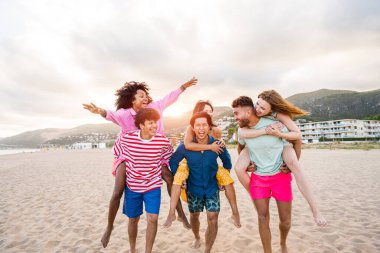 Multiethnic group of young happy friends bonding outside, having fun on summertime vacation - Multicultural cheerful people with summer clothes enjoying summer holidays, concepts about youth, friendship and positive emotion