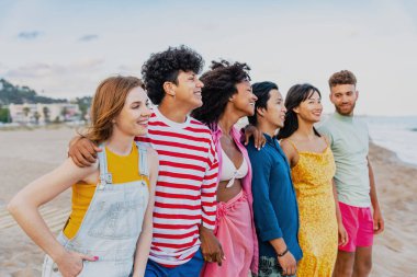 Multiethnic group of young happy friends bonding outside, having fun on summertime vacation - Multicultural cheerful people with summer clothes enjoying summer holidays, concepts about youth, friendship and positive emotion