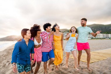Multiethnic group of young happy friends bonding outside, having fun on summertime vacation - Multicultural cheerful people with summer clothes enjoying summer holidays, concepts about youth, friendship and positive emotion