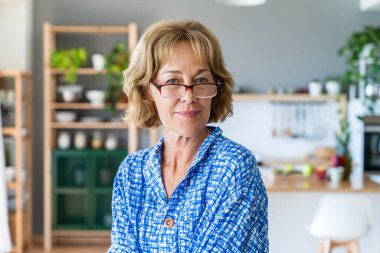 Beautiful mature senior woman at home, domestic life and leisure moments - 50-60 years old pretty female adult with eyeglasses portrait