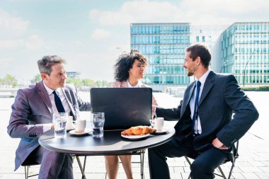 Senior businessman, caucasian man and beautiful hispanic businesswoman meeting in a bar restaurant  - Three colleagues bonding in a cafe after work