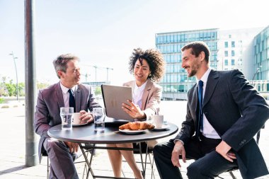 Senior businessman, caucasian man and beautiful hispanic businesswoman meeting in a bar restaurant  - Three colleagues bonding in a cafe after work