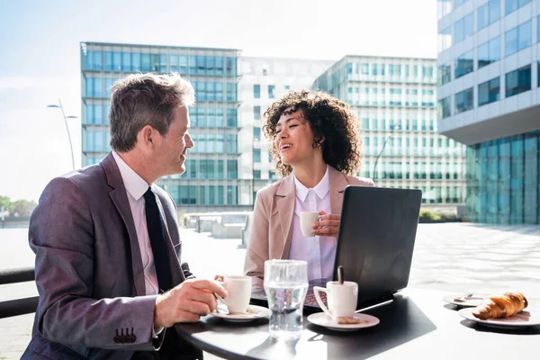 Senior businessman and beautiful hispanic businesswoman meeting in a bar restaurant  - Two colleagues bonding in a cafe after work