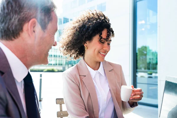 Senior businessman and beautiful hispanic businesswoman meeting in a bar restaurant  - Two colleagues bonding in a cafe after work