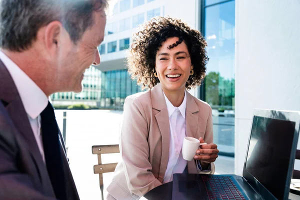 Senior businessman and beautiful hispanic businesswoman meeting in a bar restaurant  - Two colleagues bonding in a cafe after work