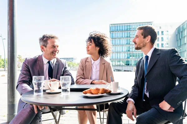 Senior businessman, caucasian man and beautiful hispanic businesswoman meeting in a bar restaurant  - Three colleagues bonding in a cafe after work