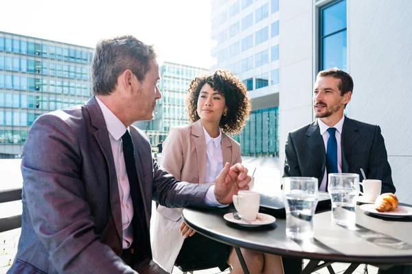 Senior businessman, caucasian man and beautiful hispanic businesswoman meeting in a bar restaurant  - Three colleagues bonding in a cafe after work