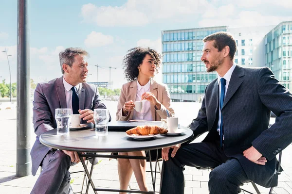 Senior businessman, caucasian man and beautiful hispanic businesswoman meeting in a bar restaurant  - Three colleagues bonding in a cafe after work