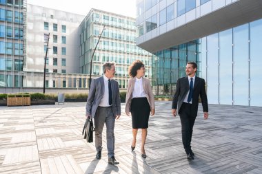 Multiracial group of business people bonding outdoors - International business corporate team wearing elegant suit meeting in a business park