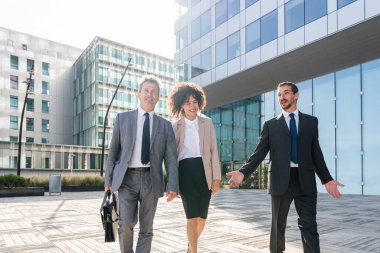 Multiracial group of business people bonding outdoors - International business corporate team wearing elegant suit meeting in a business park