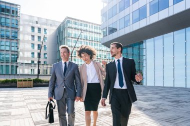 Multiracial group of business people bonding outdoors - International business corporate team wearing elegant suit meeting in a business park
