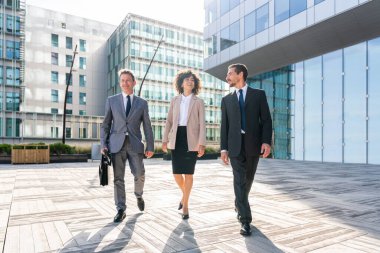 Multiracial group of business people bonding outdoors - International business corporate team wearing elegant suit meeting in a business park