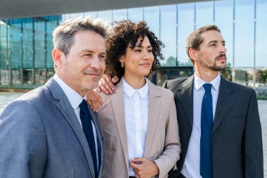 Multiracial group of business people bonding outdoors - International business corporate team wearing elegant suit meeting in a business park