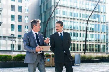Multiracial group of business people bonding outdoors - International business corporate team wearing elegant suit meeting in a business park