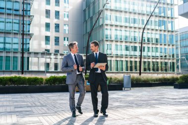 Multiracial group of business people bonding outdoors - International business corporate team wearing elegant suit meeting in a business park