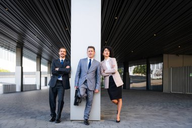 Multiracial group of business people bonding outdoors - International business corporate team wearing elegant suit meeting in a business park