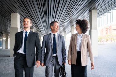 Multiracial group of business people bonding outdoors - International business corporate team wearing elegant suit meeting in a business park