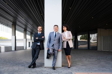 Multiracial group of business people bonding outdoors - International business corporate team wearing elegant suit meeting in a business park