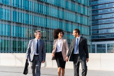 Multiracial group of business people bonding outdoors - International business corporate team wearing elegant suit meeting in a business park