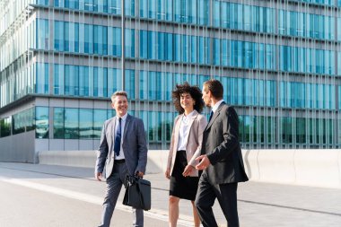 Multiracial group of business people bonding outdoors - International business corporate team wearing elegant suit meeting in a business park