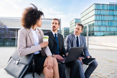 Multiracial group of business people bonding outdoors - International business corporate team wearing elegant suit meeting in a business park