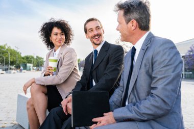 Multiracial group of business people bonding outdoors - International business corporate team wearing elegant suit meeting in a business park