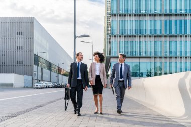 Multiracial group of business people bonding outdoors - International business corporate team wearing elegant suit meeting in a business park