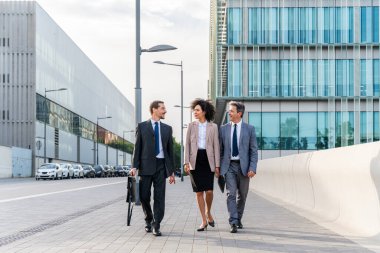 Multiracial group of business people bonding outdoors - International business corporate team wearing elegant suit meeting in a business park