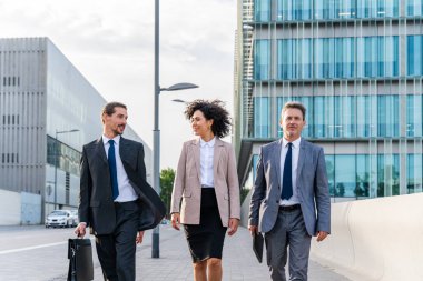 Multiracial group of business people bonding outdoors - International business corporate team wearing elegant suit meeting in a business park