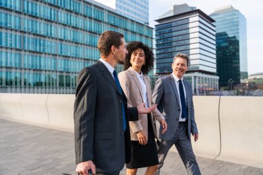Multiracial group of business people bonding outdoors - International business corporate team wearing elegant suit meeting in a business park