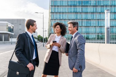 Multiracial group of business people bonding outdoors - International business corporate team wearing elegant suit meeting in a business park