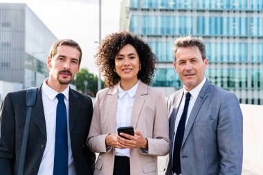 Multiracial group of business people bonding outdoors - International business corporate team wearing elegant suit meeting in a business park