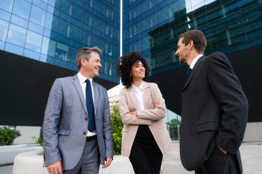 Multiracial group of business people bonding outdoors - International business corporate team wearing elegant suit meeting in a business park